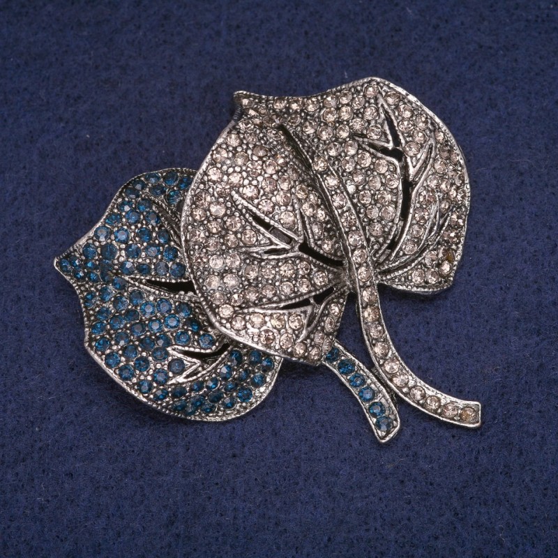 Broșă în formă de frunză cu strasuri albastre și cenusii, culoare metalului: argintiu, 54×54 mm