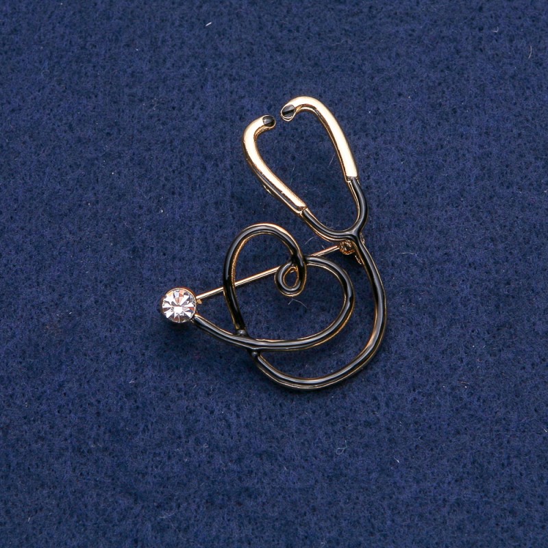 Broșă neagră – stetoscop cu inimă, piatră albă, metal auriu 43×33 mm