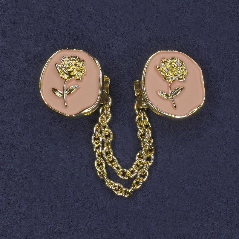 Broșă pentru cardigane – email roz, metal auriu, diametru ~20 mm, lanț ~9 cm