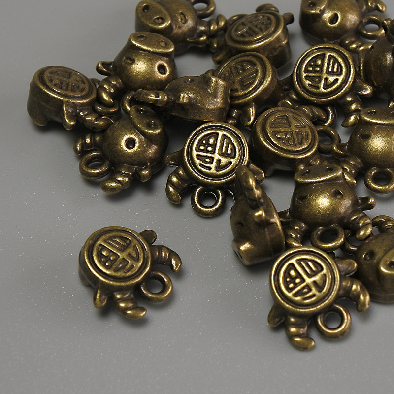 Pandantiv taur culoare bronz, dimensiuni 10×9×5 mm, gaură de 1 mm, ambalaj de 20 g (~17 buc.)