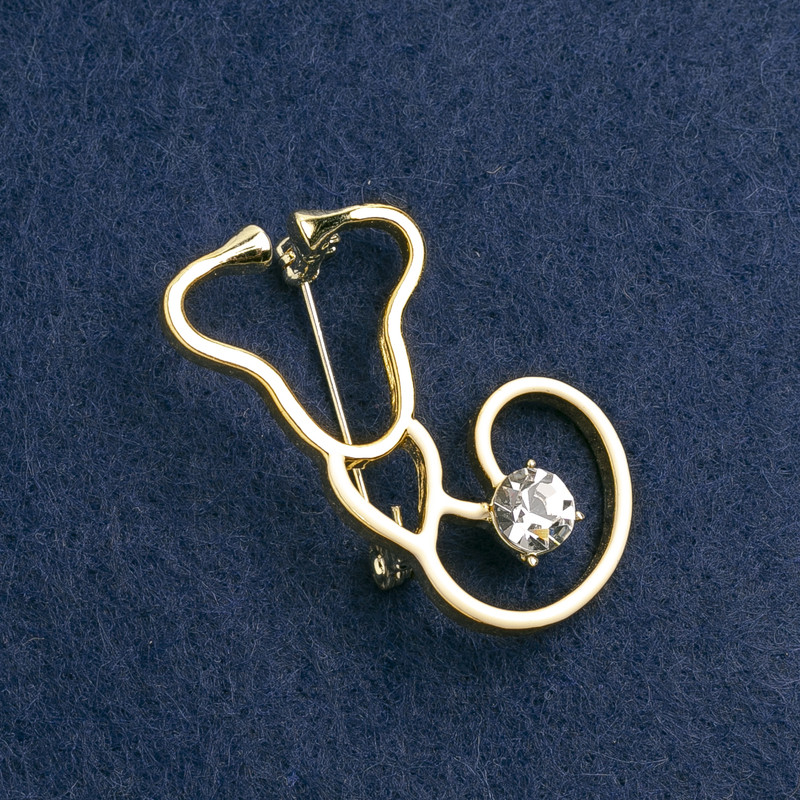 Broșă stetoscop email alb, cu piatră albă, metal auriu 42×25 mm