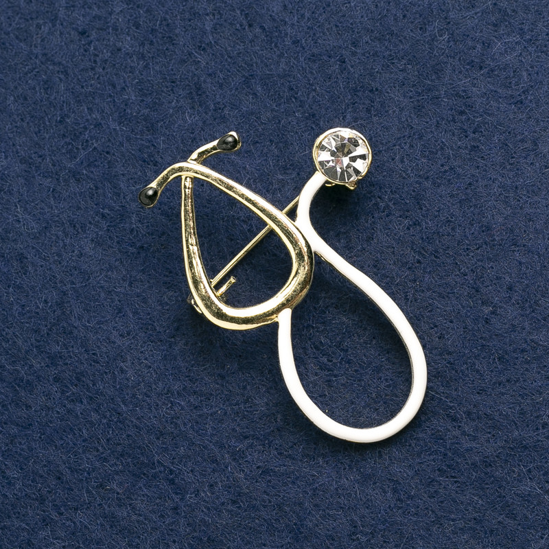 Broșă Stetoscop email alb, cu piatră albă, metal auriu 43×29 mm